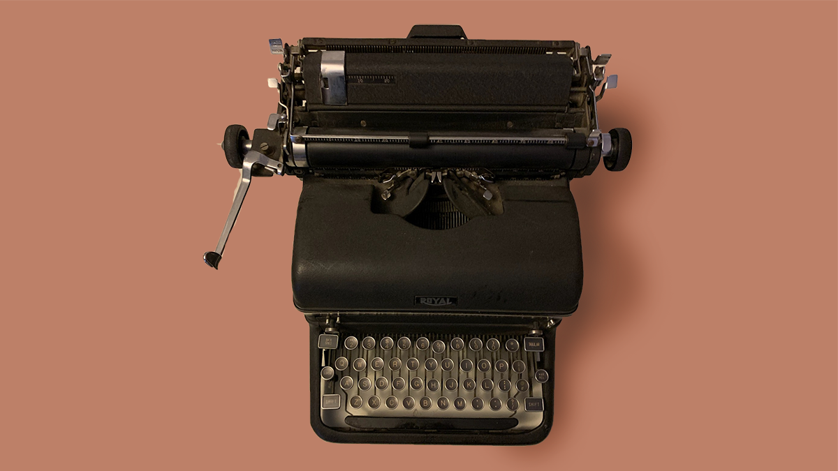 Black typewriter on beige background